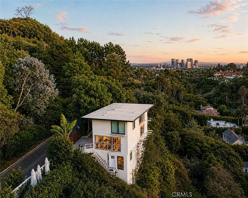 Aerial view of the 1311 Braeridge Drive residence on its canyon ridge with the Century City skyline at sunset